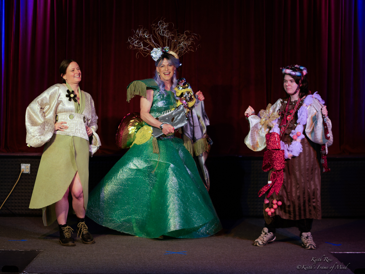 Trashion Show participants wearing recycled-material fashions on stage
